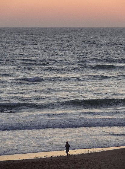 Lone walker after Novo Sancti Petri beach sunset