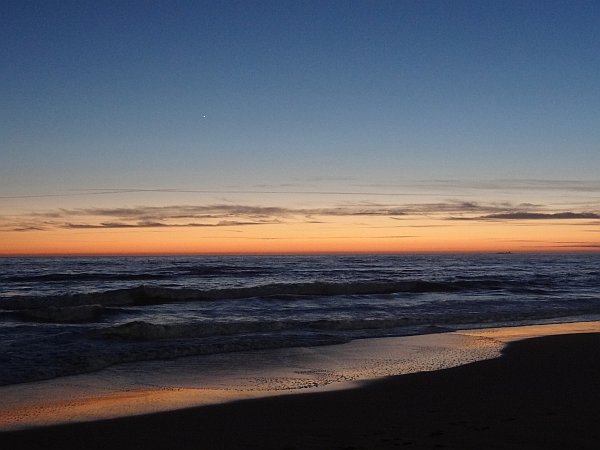 Dusk Sky reflections in water running onto Barrosa beach