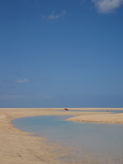 Surfer walking across Sotavento lagoon
