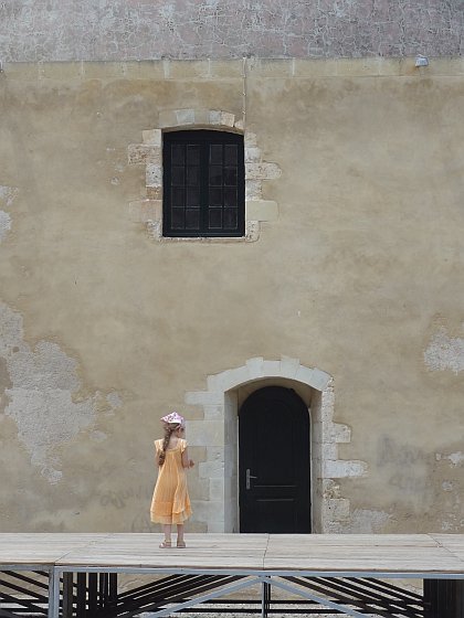 Girl in front of wall of mosque at Chania harbour