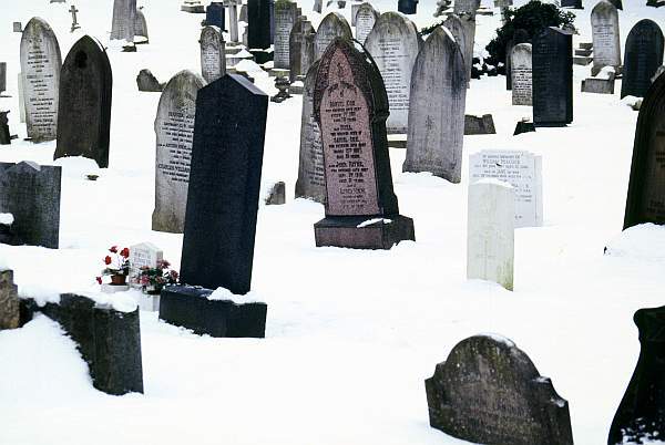 Gravestones in snow covered Welford Road Cemetary, Leicester