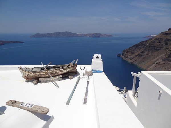 Old fishing boat on house roof in Firostefani