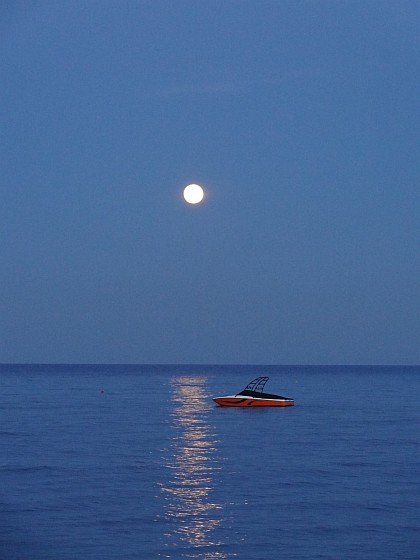 Rising moon above anchored boat