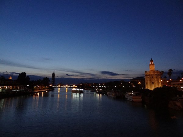 Guadalquivir river with Torre del Oro and Torre Pelli (Cajasol Tower) at night
