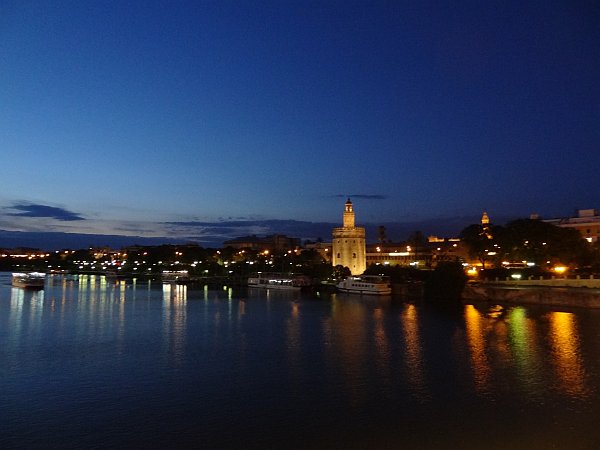 Guadalquivir river with Torre del Oro and cathedral at night